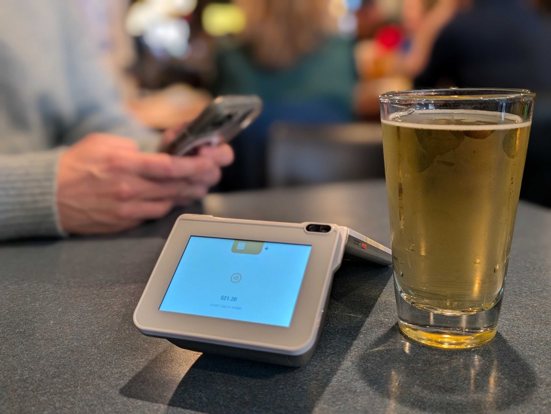 The Fare terminal displays a price and payment prompts. A tall glass of beer sits next to the terminal.