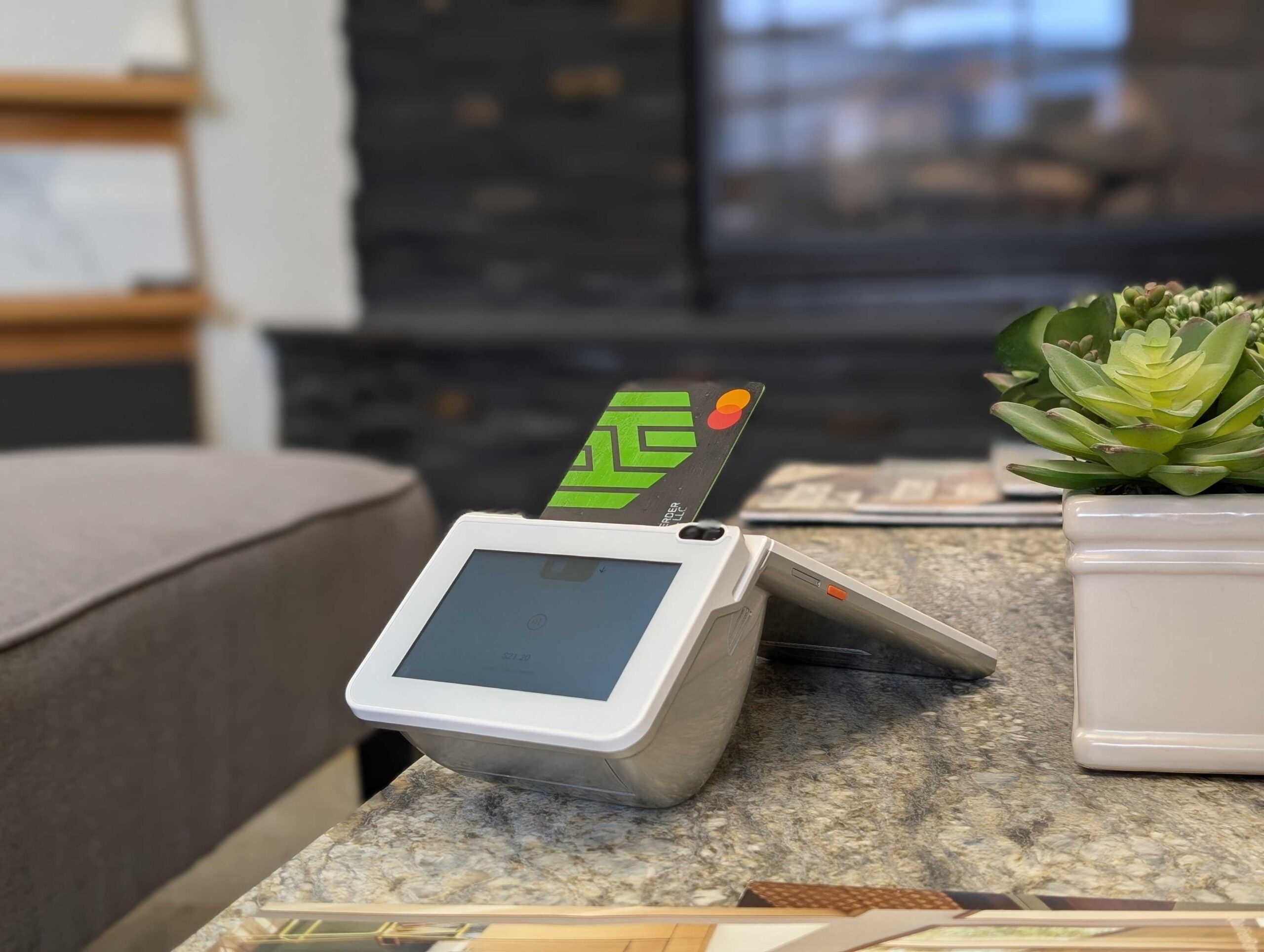 A credit card sticks out of the card slot on the Fare terminal on the counter