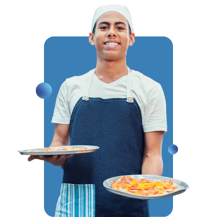 A cook holds a pizza on a pan in each hand