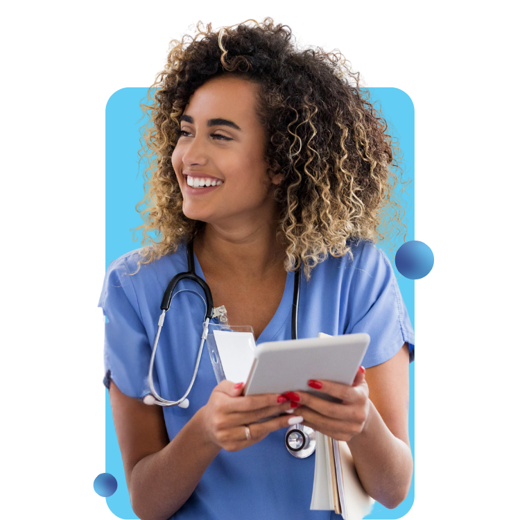 A smiling woman in scrubs wears a stethoscope and holds a tablet.