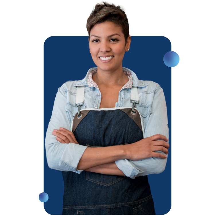 A female business owner wearing an apron smiles at the viewer